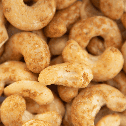 Nahaufnahme von ofengerösteten Cashewkernen mit Chili, die eine knusprige Textur und würzige Paprikanote zeigen, ideal für einen aromatischen Snack.