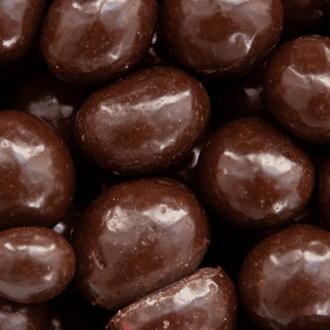 Nahaufnahme von Kaffeebohnen mit Zartbitterschokolade umhüllt. Perfekte Balance aus kräftigem Kaffee und feiner Schokolade.