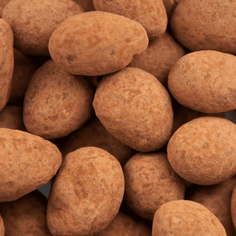 Nahaufnahme von Trüffelmandeln mit Kakao, die mit belgischer Schokolade überzogen sind. Hochwertiger Snack für besondere Genussmomente.