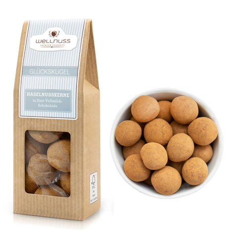 Glückskugel Haselnusskerne in Vollmilch-Zimt-Schokolade, 60 g Packung mit Sichtfenster. Knackige Haselnüsse umhüllt von belgischer Schokolade und Zimt.