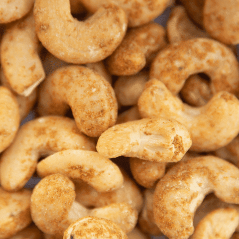 Nahaufnahme von ofengerösteten Cashewkernen mit Curry. Die feine Currymischung verleiht den knackigen Cashews eine würzig-fruchtige Note.
