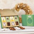 Geschenkkarton mit 4 Ostersnacks, gefüllt mit Schokoladenmandeln in verschiedenen Geschmacksrichtungen, dekorativ präsentiert mit Osterkranz.