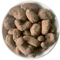 Nahaufnahme karamellisierter Cashewkerne mit Orange & Kakao in einer weißen Schale. Die knackigen Nüsse sind mit feinem Kakaopulver umhüllt.